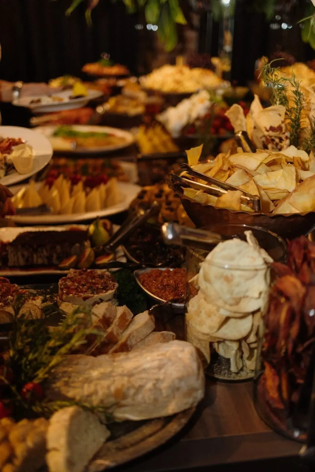 Ilha gastronômica com pães artesanais, queijos, patês e chips — gastronomia do Empório Guimarães, casa de eventos em Londrina